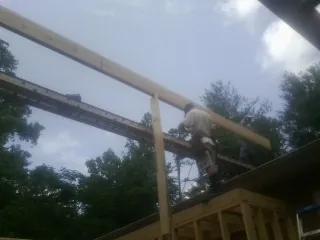 Carpenter setting a ridge beam over a new addition frame — Ice Dam Removal by Roofing Brothers in Chippewa Falls