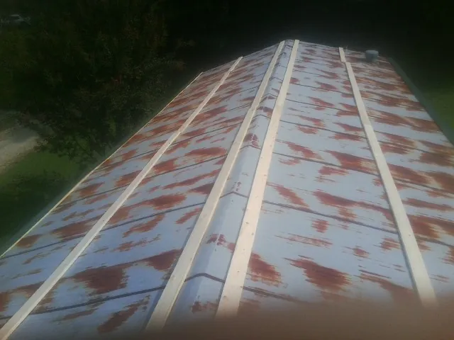 Rusted metal roof panels with new wood purlins before replacement — Storm Damage Roof Repair in Chippewa Falls by Roofing Brothers