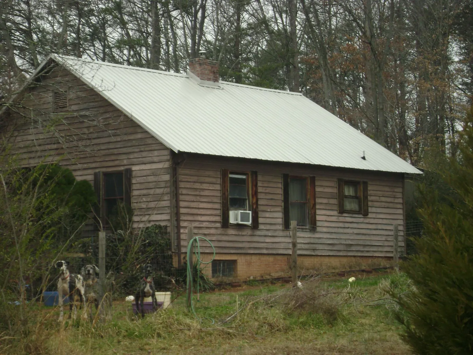 White metal roof on an old wood sided farmhouse, from a Metal Roof Installation job in Chippewa Falls